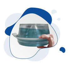 Hand holding a blue and silver dog bowl against a white background